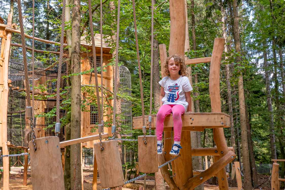 Ein Mädchen spielt auf einer der unzähligen Spielstationen im Abenteuerwald Elsass, einem Abenteuerspielplatz für groß und klein.