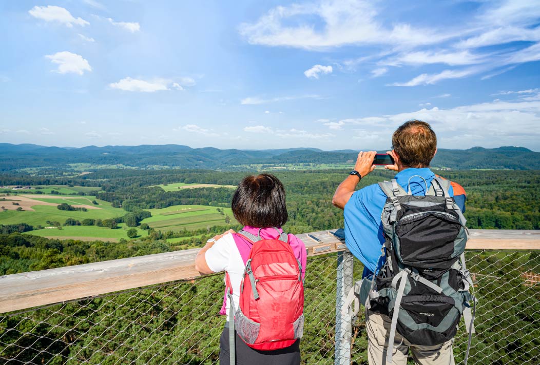 Un couple découvre la vue panoramique depuis la tour d'observation du Chemin des Cimes Alsace