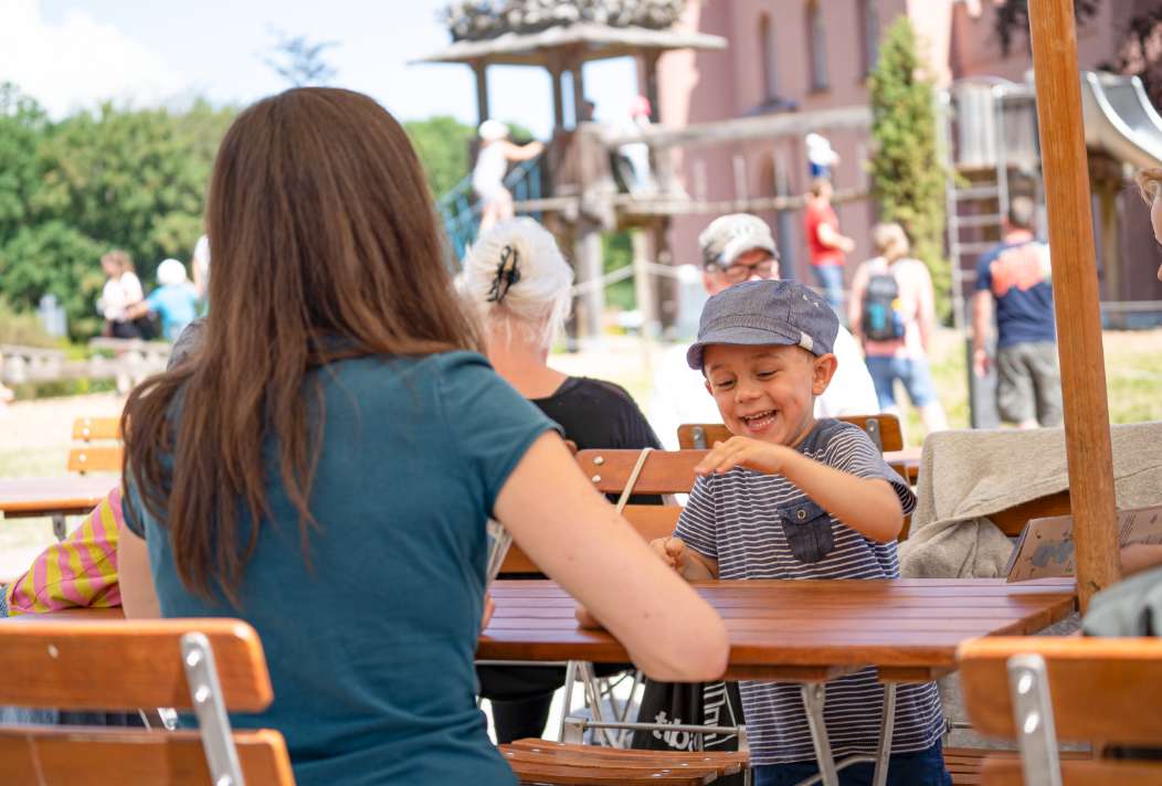 Ein Kind freut sich über den Platz auf der Terrasse im Restaurant Boomhus auf Rügen.