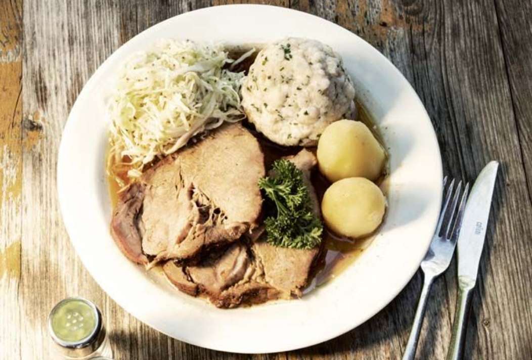 Traditional Austrian cuisine, roast pork with bread and potato dumplings and cabbage