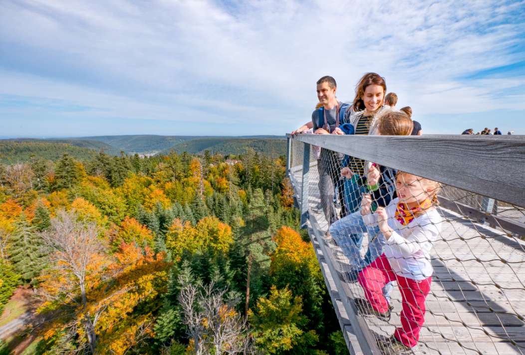 Eine Familie genießt den Ausblick vom Baumwipfelpfad auf den nördlichen Schwarzwald.