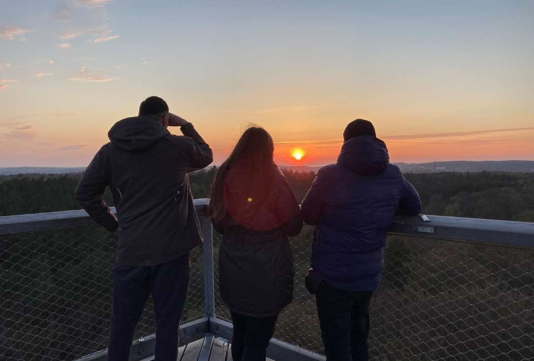 Friends watch the sunset from a very special look-out post.